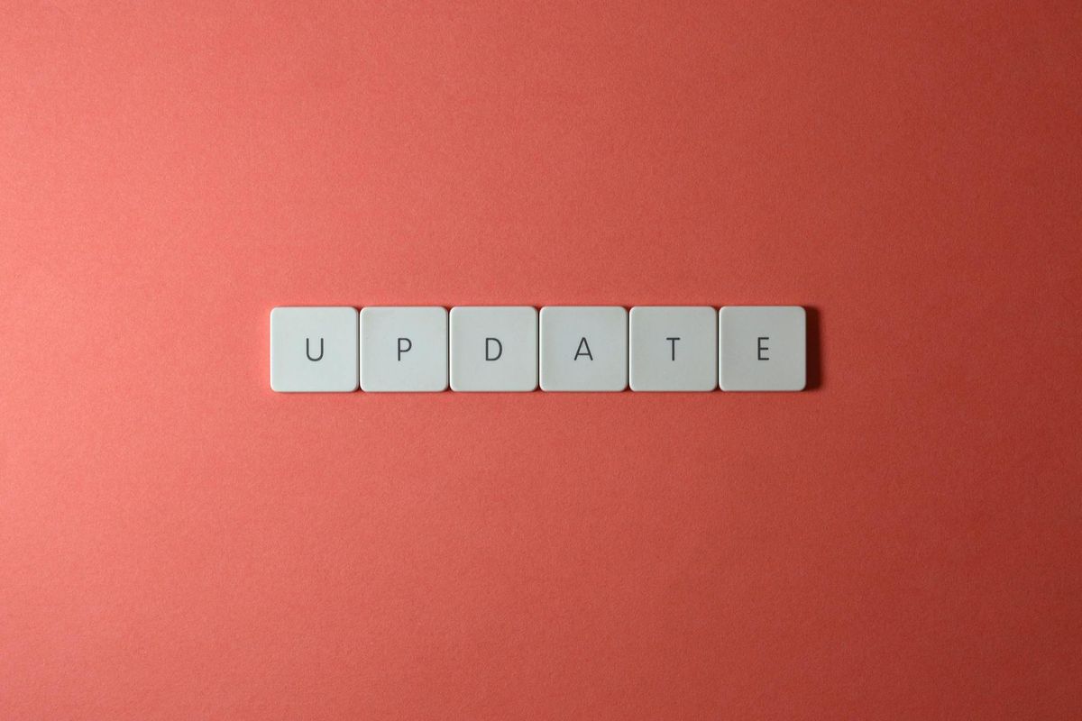 White letter tiles spelling "UPDATE" on coral background